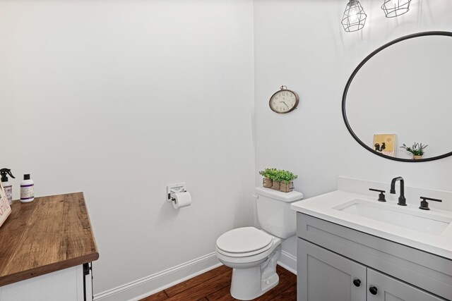 bathroom with wood-type flooring, toilet, and vanity