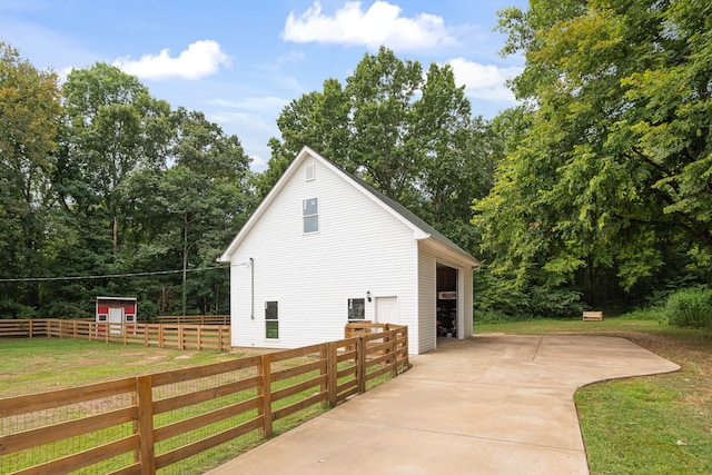 view of side of property with a lawn, an outbuilding, and a garage