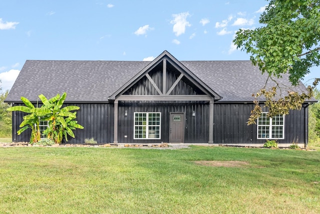 view of front of house featuring a shingled roof, board and batten siding, and a front lawn