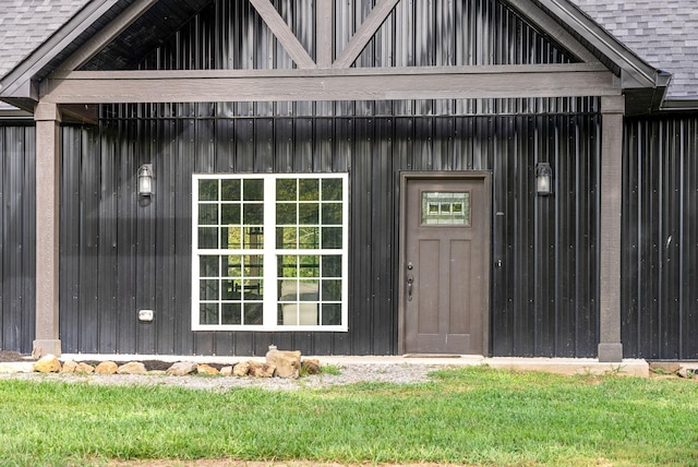 view of exterior entry featuring roof with shingles