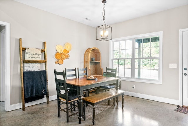 dining space featuring a notable chandelier and concrete floors