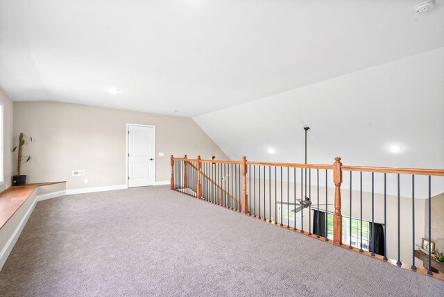 spare room with carpet flooring and lofted ceiling