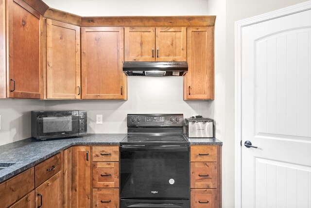 kitchen featuring dark stone countertops and black appliances