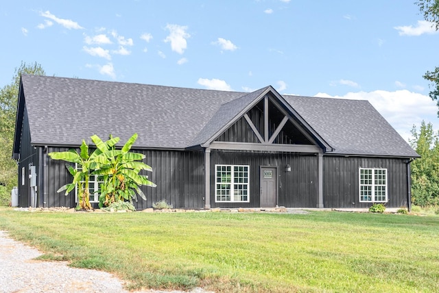 view of front of property featuring roof with shingles and a front yard