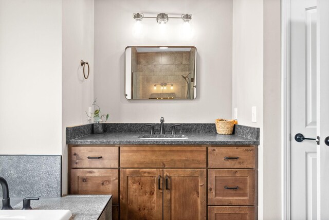 bathroom featuring vanity, walk in shower, and tasteful backsplash