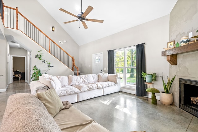 living room with ceiling fan, high vaulted ceiling, and a fireplace