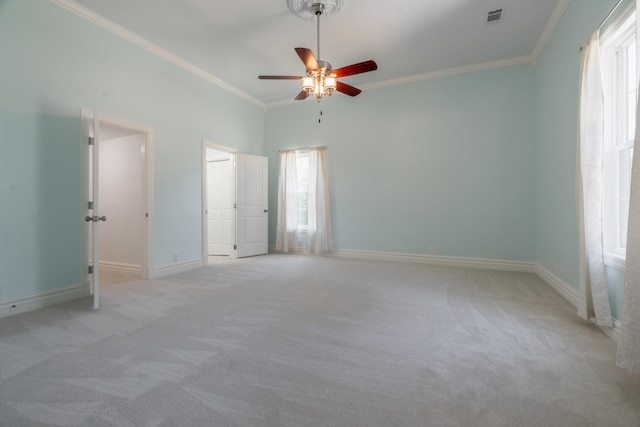 unfurnished bedroom with ceiling fan, crown molding, and light colored carpet