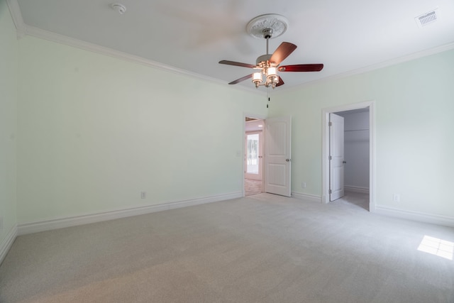 unfurnished room featuring ceiling fan, light carpet, and crown molding