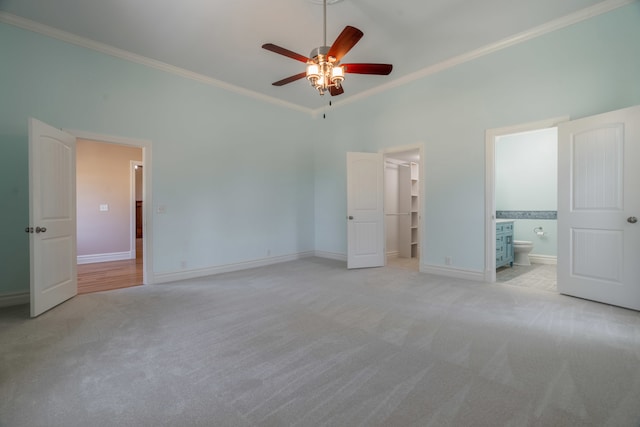 unfurnished bedroom featuring ceiling fan, ornamental molding, light colored carpet, and ensuite bathroom