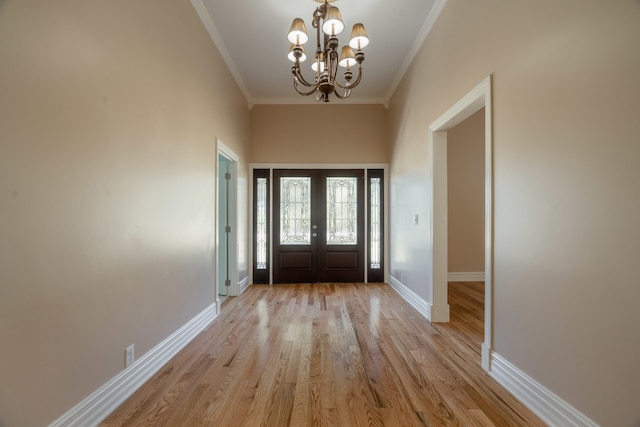 entryway with light hardwood / wood-style floors, a chandelier, and crown molding