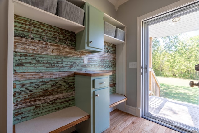 interior space featuring green cabinets, open shelves, light wood finished floors, and baseboards