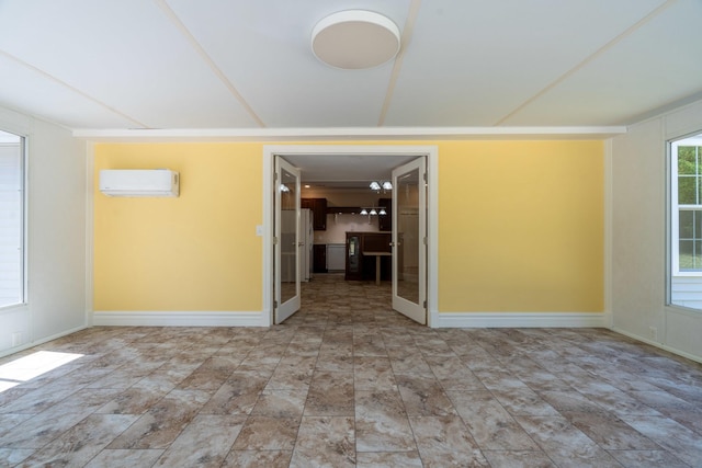 unfurnished room featuring a wall mounted AC and baseboards