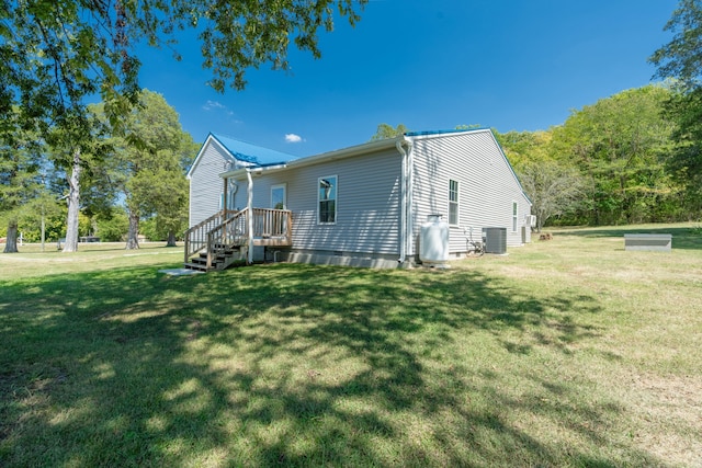 view of home's exterior featuring central AC unit and a yard