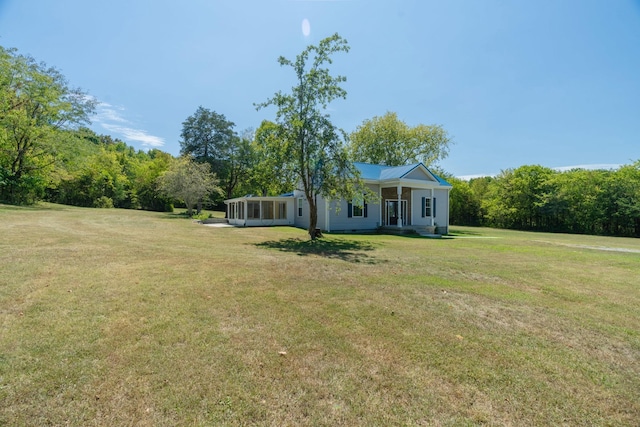 view of front of property featuring a sunroom and a front lawn