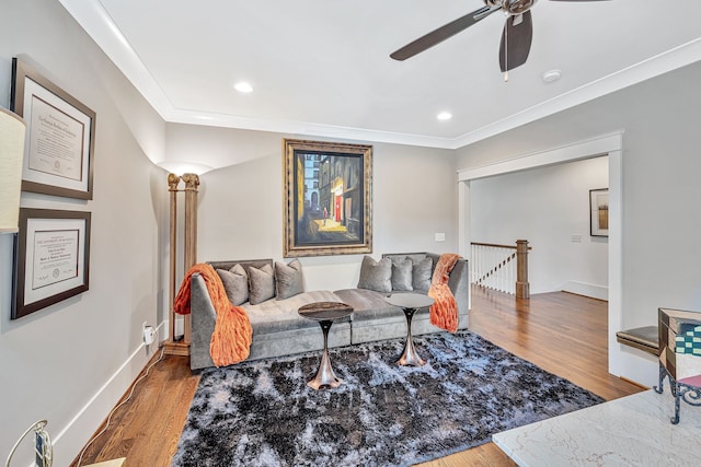 living room with crown molding, hardwood / wood-style floors, and ceiling fan