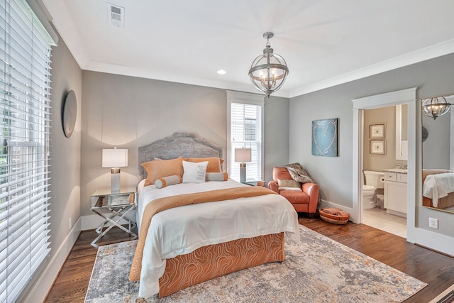 bedroom featuring crown molding, connected bathroom, a notable chandelier, and wood-type flooring