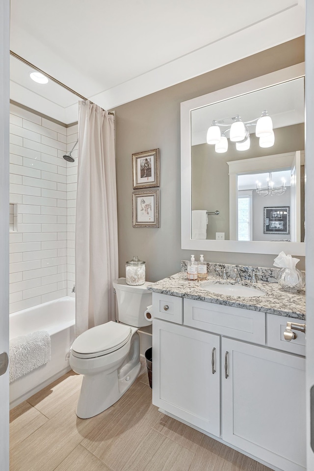 full bathroom with vanity, a notable chandelier, hardwood / wood-style floors, toilet, and shower / bath combo with shower curtain