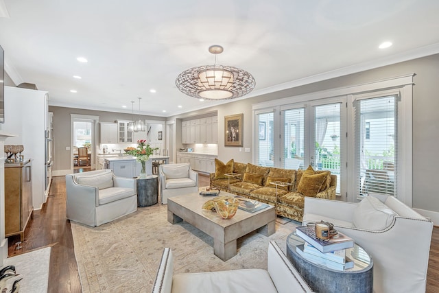 living room featuring crown molding and light hardwood / wood-style floors