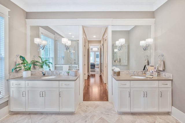 bathroom with ornamental molding, vanity, a wealth of natural light, and hardwood / wood-style flooring