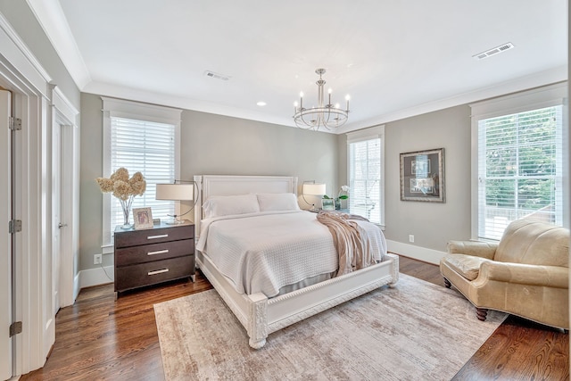 bedroom with crown molding, dark hardwood / wood-style flooring, and a notable chandelier