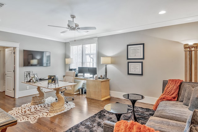 living room with wood-type flooring, crown molding, and ceiling fan