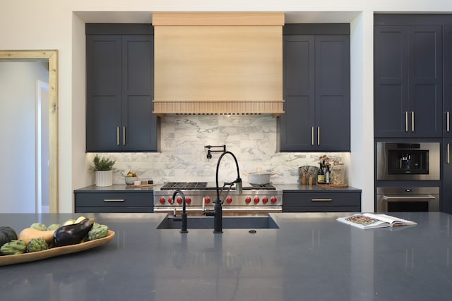 kitchen featuring sink, decorative backsplash, stainless steel double oven, and custom range hood