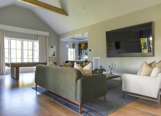 living room featuring a wealth of natural light, hardwood / wood-style flooring, high vaulted ceiling, and beam ceiling