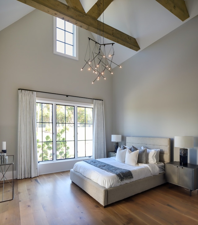 bedroom featuring hardwood / wood-style flooring, an inviting chandelier, and beamed ceiling