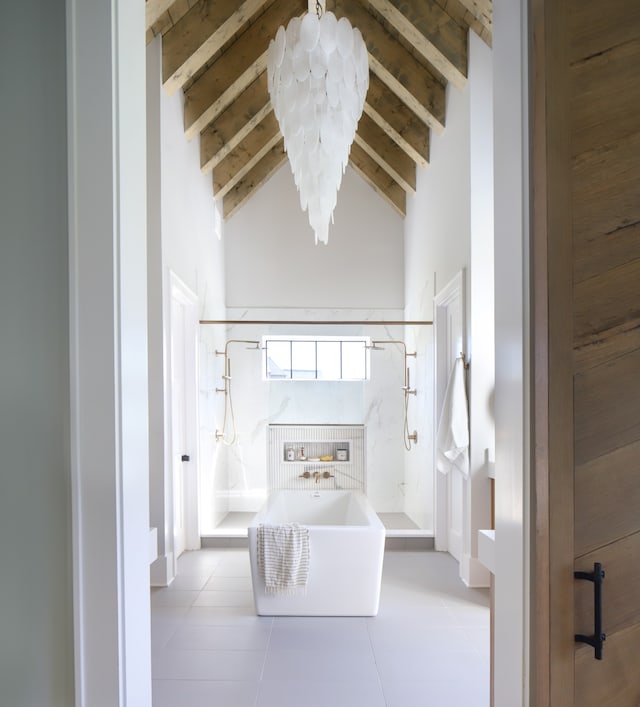 unfurnished bedroom with light tile patterned flooring, beam ceiling, and high vaulted ceiling