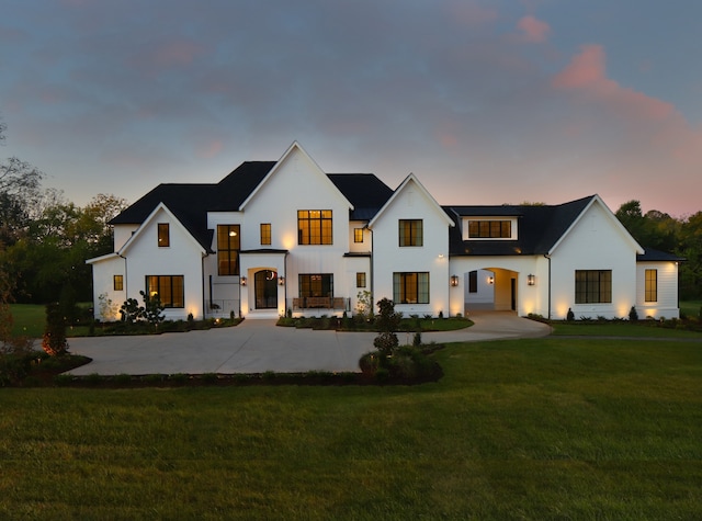 back house at dusk featuring a yard