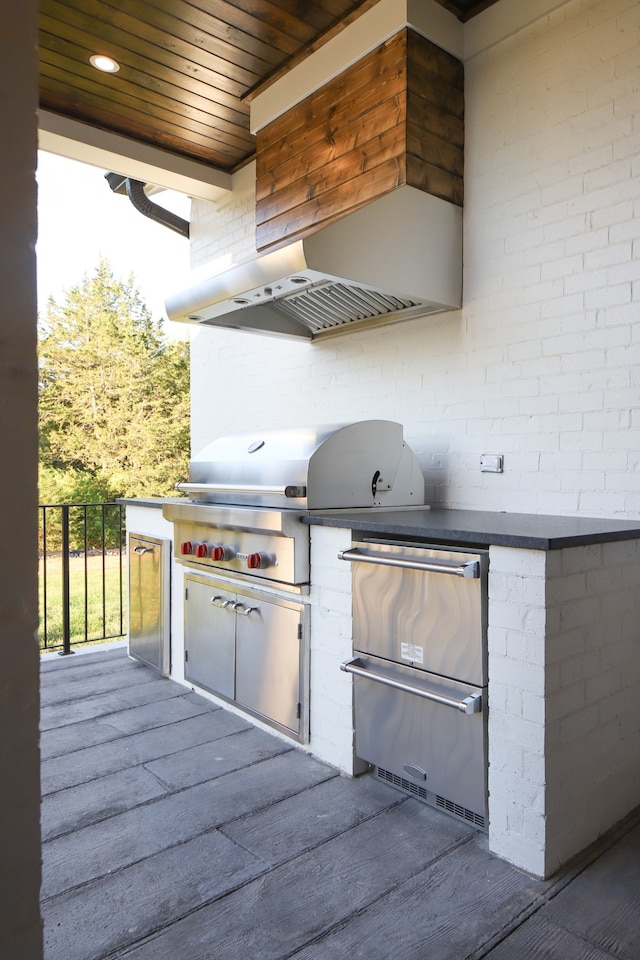 view of patio featuring exterior kitchen and a grill