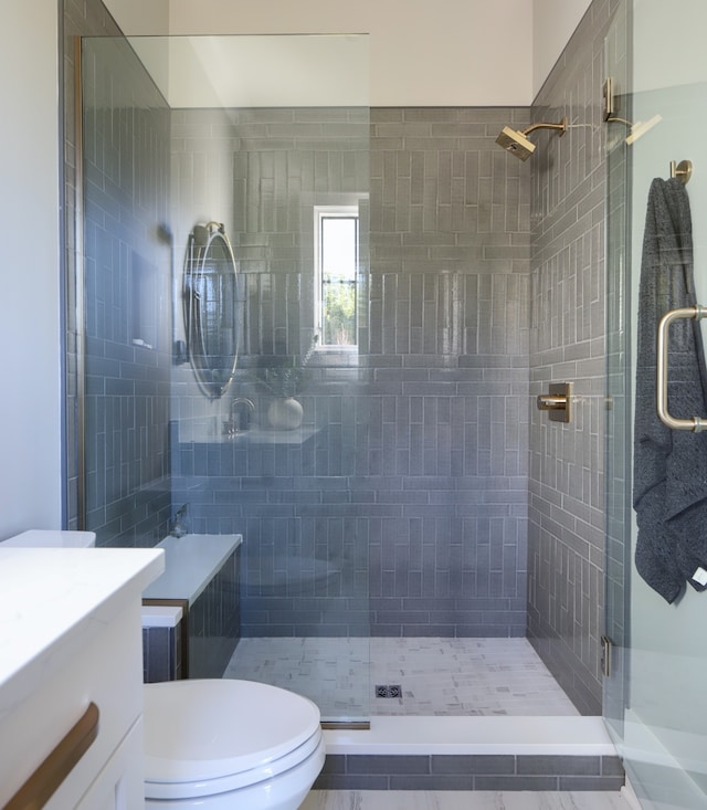 bathroom featuring tile patterned floors, toilet, walk in shower, and vanity