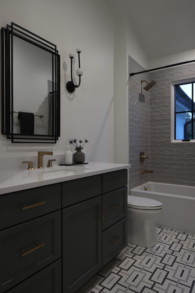 full bathroom with tile patterned floors, toilet, tiled shower / bath, and vanity