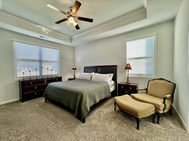 bedroom featuring ceiling fan, light colored carpet, ornamental molding, and a tray ceiling