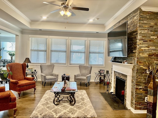 living room with hardwood / wood-style flooring, ornamental molding, and a tray ceiling