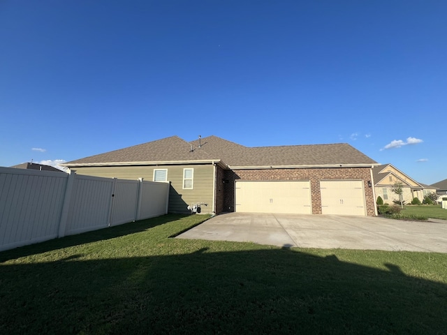 exterior space featuring a garage and a lawn