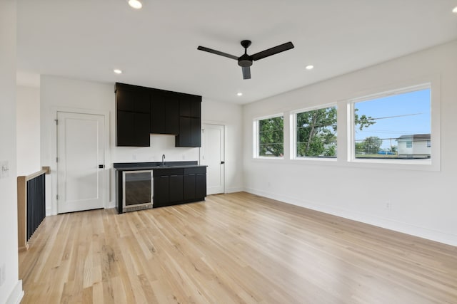 kitchen with light wood-type flooring, beverage cooler, and ceiling fan