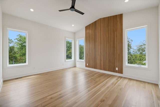 empty room featuring light hardwood / wood-style flooring, lofted ceiling, and plenty of natural light