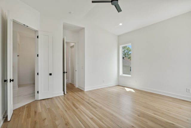 empty room with ceiling fan and light hardwood / wood-style flooring