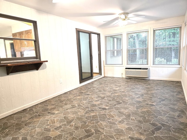 empty room featuring wood walls, ceiling fan, and a wall mounted AC