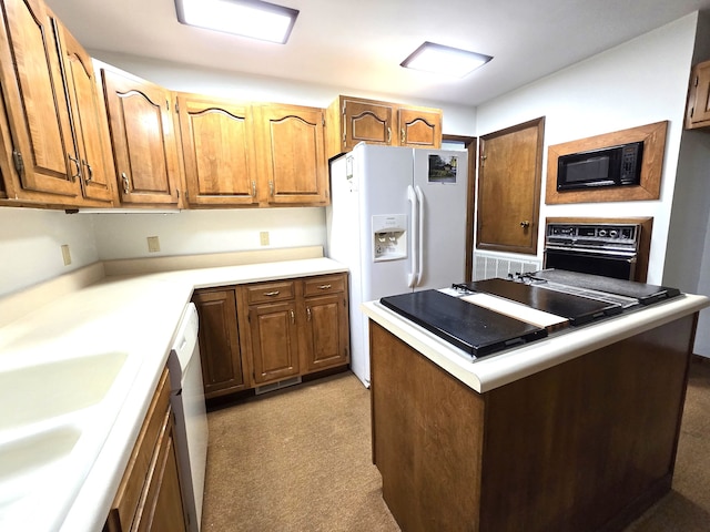 kitchen featuring light carpet, black appliances, and sink