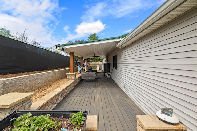 wooden deck with a fenced backyard and ceiling fan