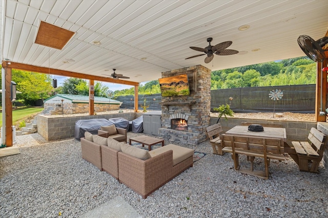 view of patio / terrace featuring an outdoor living space with a fireplace, ceiling fan, and fence