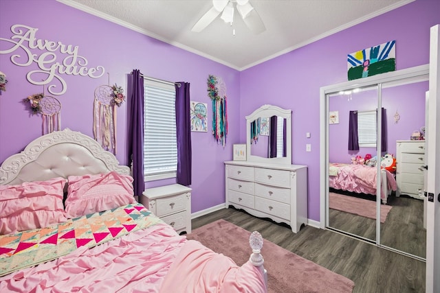 bedroom with baseboards, dark wood finished floors, a ceiling fan, ornamental molding, and a closet