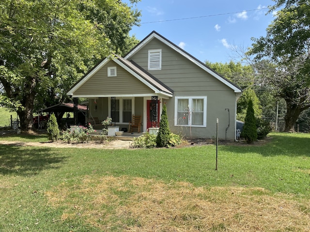 back of property featuring covered porch and a yard