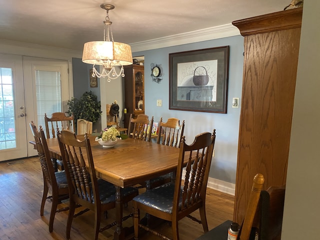 dining area featuring a notable chandelier, ornamental molding, and hardwood / wood-style flooring