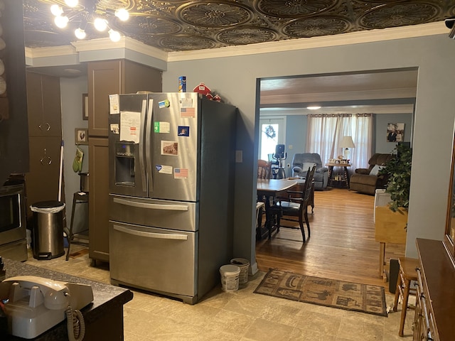 kitchen featuring crown molding, stainless steel appliances, light hardwood / wood-style flooring, and an inviting chandelier