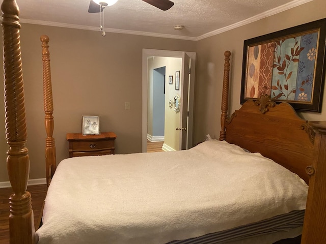 bedroom with a textured ceiling, baseboards, crown molding, and wood finished floors