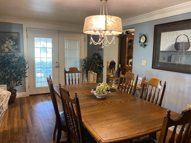 dining space with a notable chandelier, ornamental molding, hardwood / wood-style flooring, and french doors