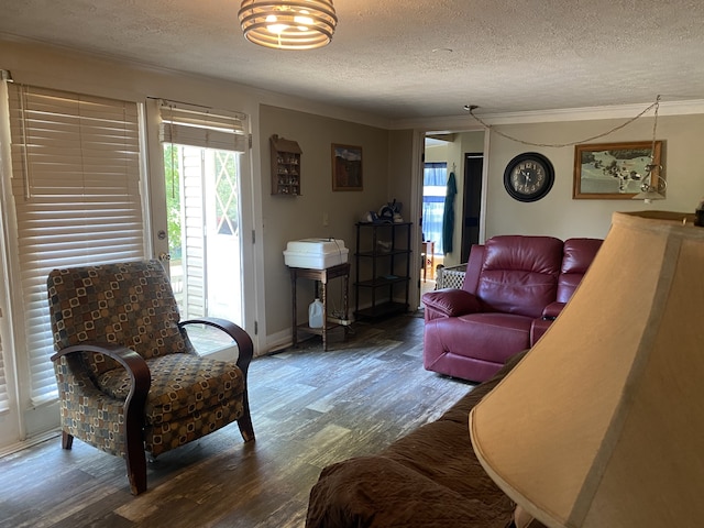 living room with a textured ceiling, crown molding, and hardwood / wood-style floors